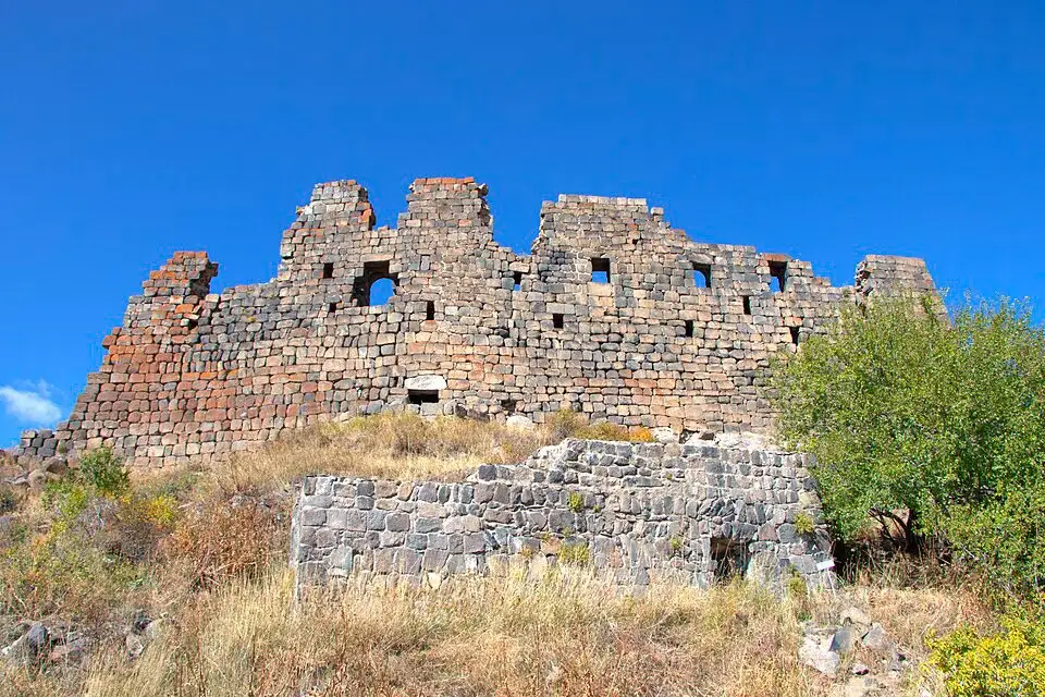 Stone walls of Amberd Fortress under a blue sky