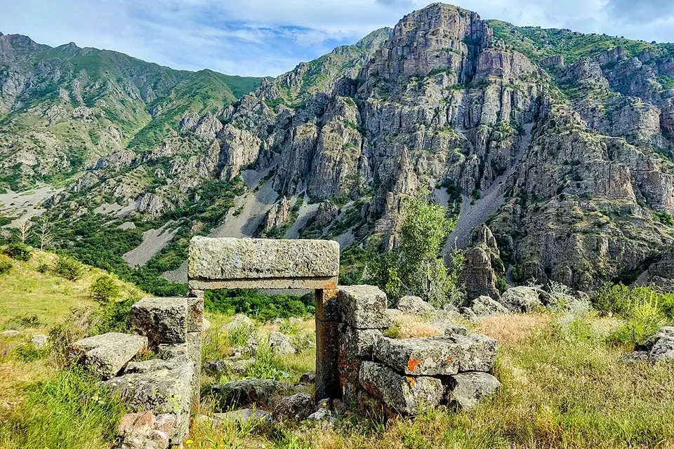 Ruins of the Zorats Church enclosure with mountains behind